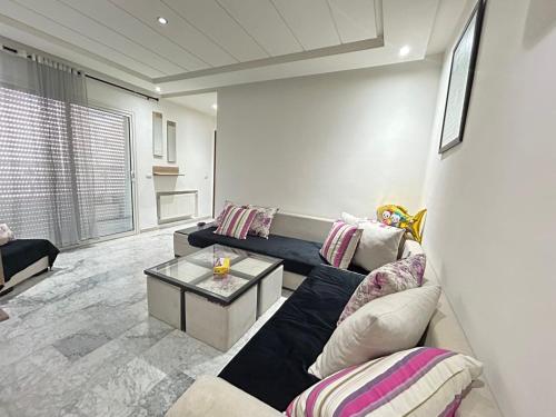 uma sala de estar com um sofá e uma mesa em Appartement haut standing a sousse em La Corniche