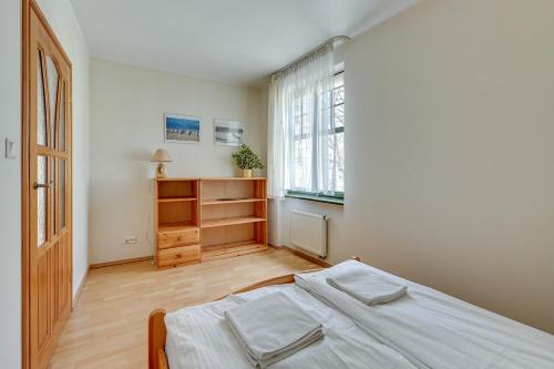 ソポトにあるApartament Słoneczny by Grand Apartmentsの白いベッドルーム(ベッド1台、窓付)