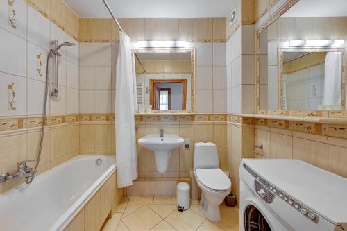 ソポトにあるApartament Słoneczny by Grand Apartmentsのバスルーム(トイレ、洗面台、バスタブ付)