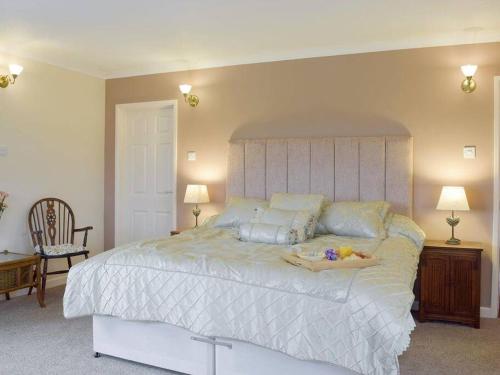 a bedroom with a large white bed with a large headboard at Green Haven Pembrokeshire in Pembrokeshire
