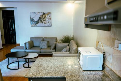 ein Wohnzimmer mit einem Sofa und einem Tisch in der Unterkunft Noonluxuryliving in Kampala