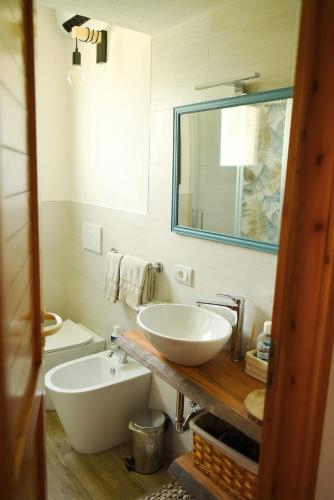 a bathroom with a sink and a toilet and a mirror at La dimora di Dafne 48 in Monzuno