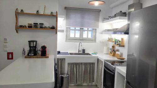 a white kitchen with a sink and a counter at Stavros Residence in Mármara