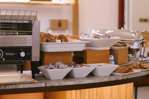 a counter with plates of bread and bowls of food at Hu Hotel Memphis in Memphis