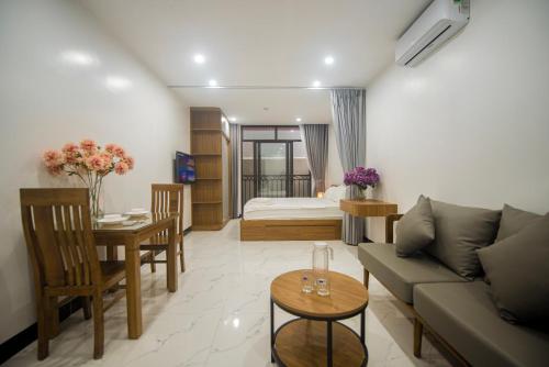 een woonkamer met een bank en een tafel bij Lily Home - Confetti Apartment Nguyễn Công Trứ in Hanoi