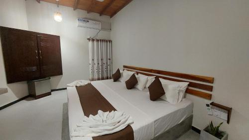 a bedroom with a bed with white sheets and pillows at The Dream Inn Guesthouse Passikudah in Batticaloa