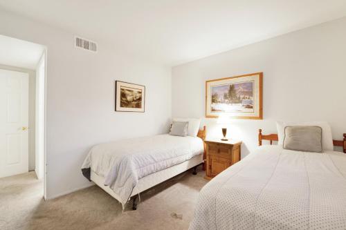 two beds in a room with white walls at Bear golf inn #1218 in Big Bear Lake