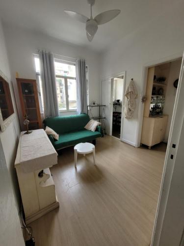 ein Wohnzimmer mit einem grünen Sofa und einem Tisch in der Unterkunft Apartamento espaçoso in Rio de Janeiro
