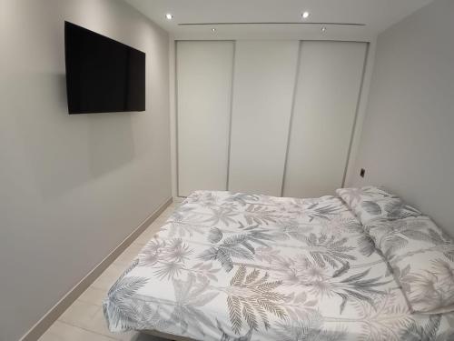 een slaapkamer met een bed en een flatscreen-tv bij Marina Club Adriatic Gibraltar - Studio Apartment in Gibraltar