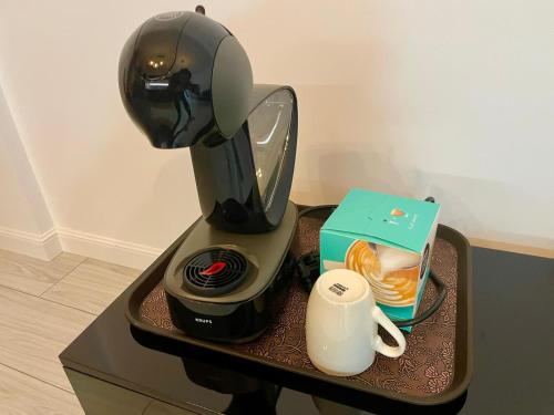 a coffee maker sitting on a table with a coffee mug at Wald Central Residence in Rădăuţi