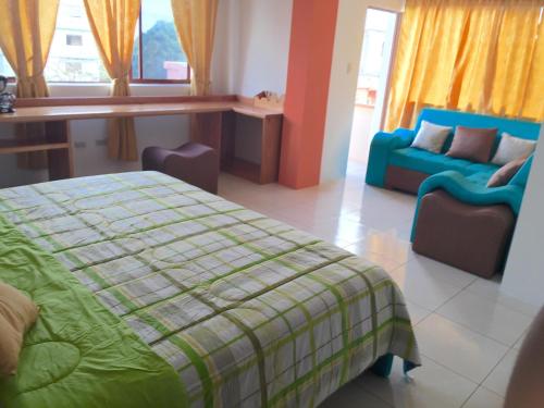 a bedroom with a bed and a couch at Hostal Tongo Reef in Puerto Baquerizo Moreno