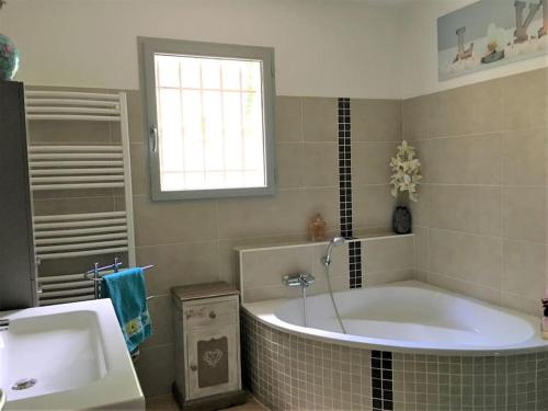 ein Badezimmer mit einer großen Badewanne und einem Waschbecken in der Unterkunft Villa climatisée Aix en Provence grande piscine, boulodrome, vue in Ventabren
