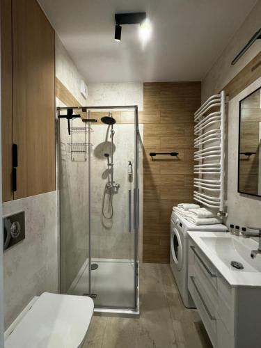 ein Bad mit einer Dusche und einer Waschmaschine in der Unterkunft Boho Apartments in Łódź
