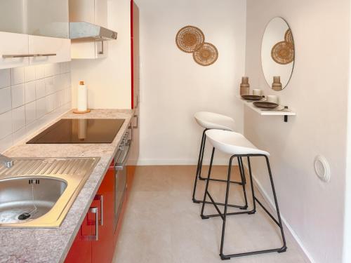 a kitchen with a sink and two bar stools at Central BOHO apartment 1 in Graz