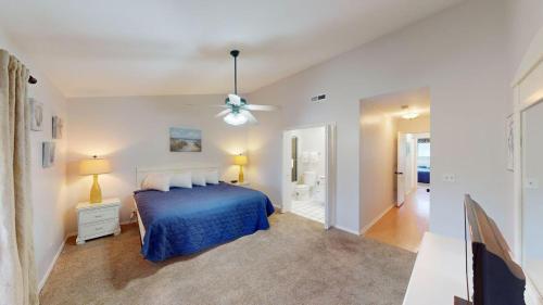 a bedroom with a blue bed and a ceiling fan at Magnolia Run 16 2BR 2BA in Pawleys Island