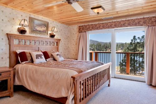 a bedroom with a large bed and a balcony at Cove lakefront chalet #2098 in Big Bear Lake