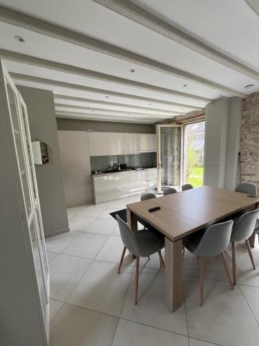 une salle à manger avec une table et des chaises en bois dans l'établissement Les Maisons de Lessac, à Guérande