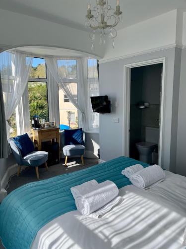 a bedroom with a large bed with a blue blanket at Bentley Lodge in Torquay