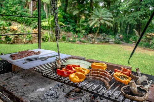 a barbecue grill with meat and vegetables on it at Hacienda La Perezosa en Cerro Azul in Cerro Azul