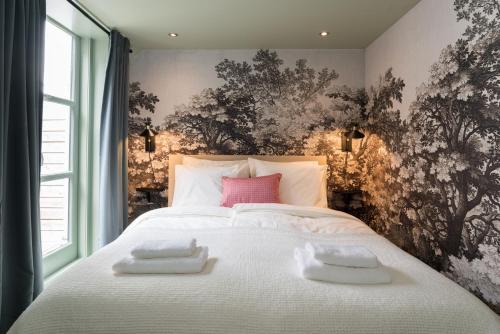 a bedroom with a bed with two towels on it at Six Boutique Hotel in Haarlem