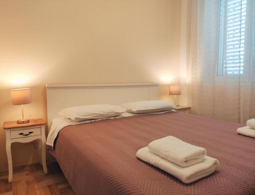 a bedroom with a bed with two pillows on it at Siesta Apartments in Šibenik
