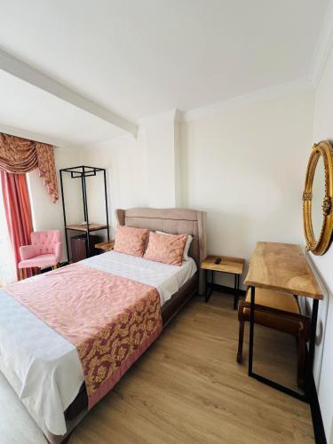 Erdemli的住宿－Roxo Beach Hotel，一间卧室配有一张床、一张桌子和一张书桌