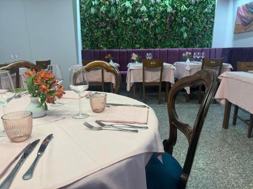 una sala da pranzo con tavoli e sedie con tovaglie bianche di Da Noi Trattoria Hotel a Vergato