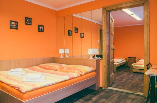 1 dormitorio con 1 cama con pared de color naranja en Sokolovna, en Karviná