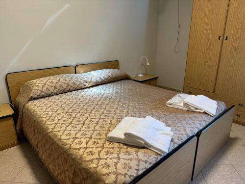 una camera da letto con un letto e asciugamani di Da Noi Trattoria Hotel a Vergato