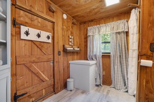 a bathroom with a toilet and a wooden wall at The Happy Hound in Alma