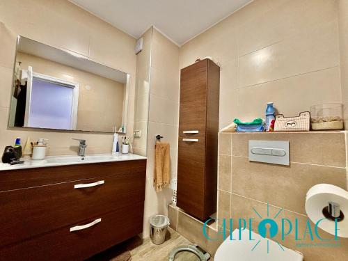 een badkamer met een wastafel, een toilet en een spiegel bij Delfín a 100 metros de la playa in Calpe