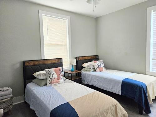 two beds in a room with two windows at Dundee Escape in Charleston