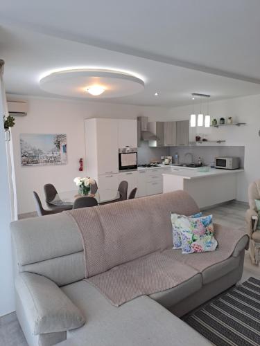 ein Wohnzimmer mit einem Sofa und einer Küche in der Unterkunft 74 temple point 3 bedroom APT in Marsaxlokk