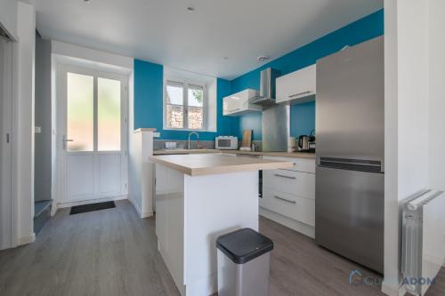 une cuisine avec des murs bleus et un comptoir. dans l'établissement Appartement au cœur de Cancale, à Cancale
