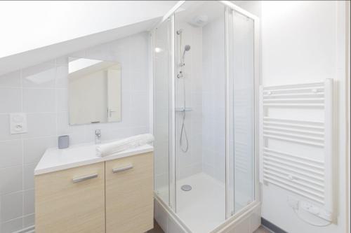 een witte badkamer met een douche en een wastafel bij LE MONKEY- 10min à pied de la Gare in Laval