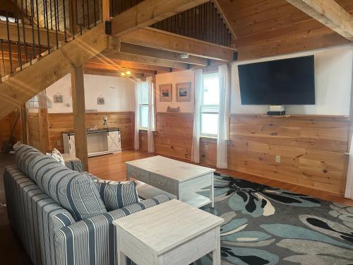 a living room with a couch and a flat screen tv at Nautical Beach Properties in Hampton