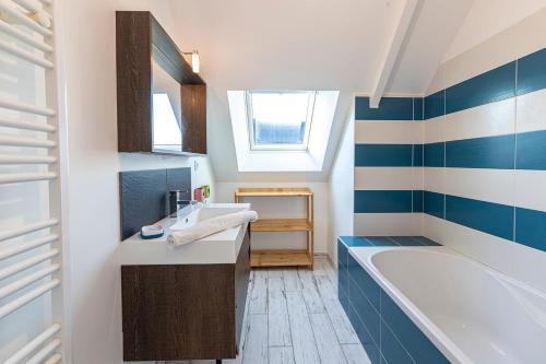 ein Badezimmer mit einem Waschbecken und einer Badewanne in der Unterkunft Pavillon d'Emeraude in Saint-Lunaire