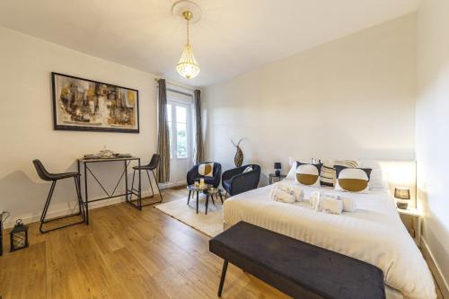 - une chambre avec un lit, une table et des chaises dans l'établissement Le Béatrix - Studio vue sur la Mayenne, à Laval