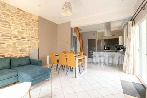 a living room with a blue couch and a table at Paisible maison dans un cadre verdoyant in Pleurtuit