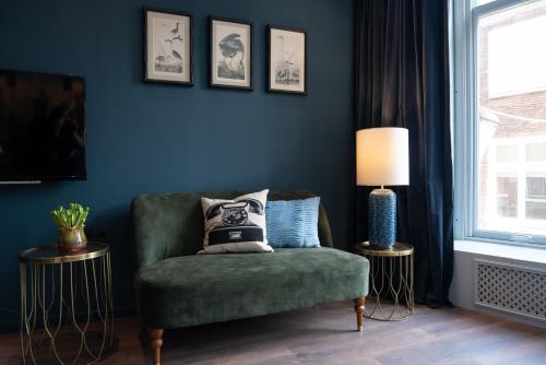 een woonkamer met een groene stoel en een lamp bij Six Boutique Hotel in Haarlem