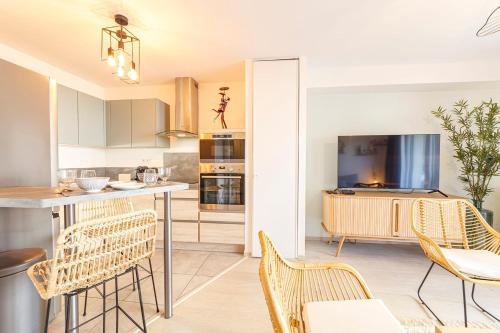 a kitchen and living room with chairs and a counter at La Kloserie appartement en résidence in Saint Malo