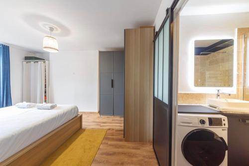 ein Schlafzimmer mit einem Bett, einem Waschbecken und einer Waschmaschine in der Unterkunft Neuf et distingué l'inévitable de Dinan in Dinan