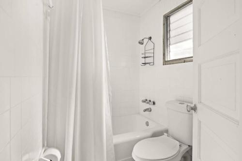 a white bathroom with a toilet and a shower at Vintage View Loft in St Petersburg