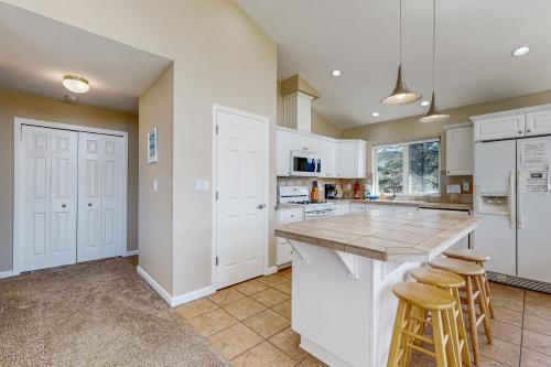 a kitchen with white cabinets and a counter with stools at Beach Escape in Rockaway Beach