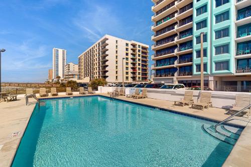 una gran piscina con sillas y edificios en Island Winds East 809, en Gulf Shores