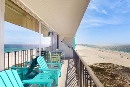 un balcón con sillas azules y la playa en Island Winds East 809, en Gulf Shores