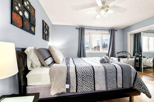 1 dormitorio con 1 cama y ventilador de techo en Comfy Getaway - Walk to West Ed Mall, en Edmonton