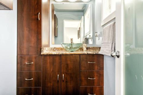 a bathroom with a sink and a mirror at Comfy Getaway - Walk to West Ed Mall in Edmonton