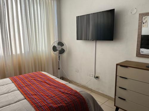 a bedroom with a fan and a television on the wall at Sumaq AirPort in Lima