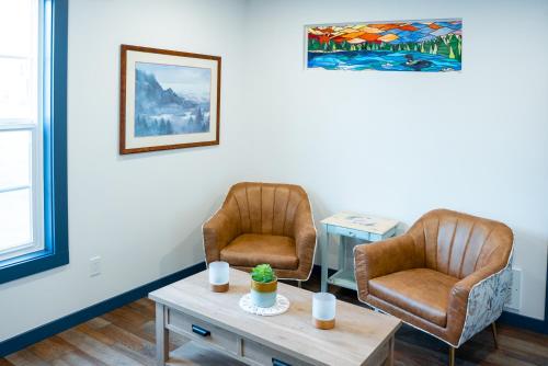 a waiting room with two chairs and a table at Vasanoja Suite 102, Hyland Hotel in Palmer